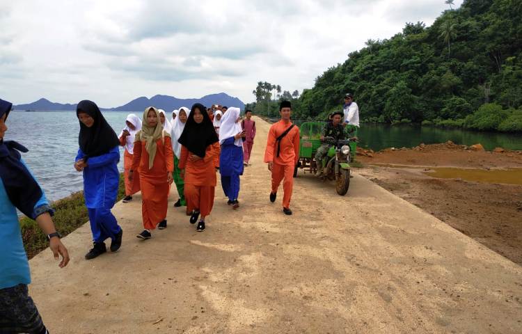 Keceriaan Pelajar saat Melintasi Jalan Baru Hasil Karya TMMD Kodim 0318 Natuna