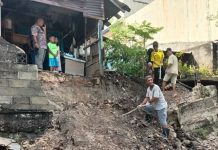 Akibat Hujan Deras, Batu Pembatas Rumah Warga Jebol, Kerugian Mencapai Puluhan Juta Warga bergotong royong membersihkan puing-puing bangunan yang runtuh akibat diterjang longsor