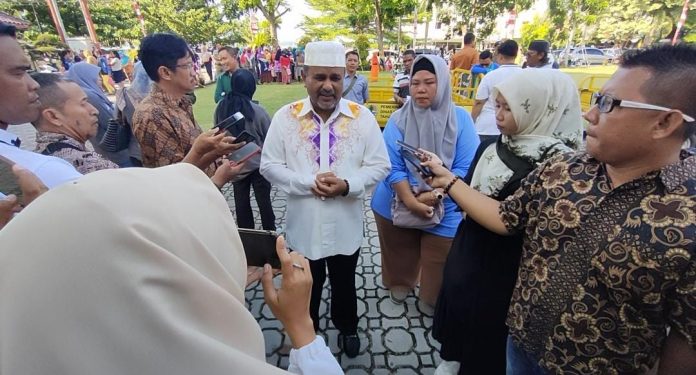 Bupati Karimun Aunur Rafiq didampingi oleh Kepala Dinas Lingkungan Hidup Kabupaten Karimun, Rita saat menyerahkan bantuan berupa 8 unit kendaraan bermotor roda 3 untuk mengangkut sampah.