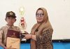 Penyerahan Rapor Semester 1, Kepsek SDN 03 Lurah Berangin Terharu dan Puji Semangat”Ayah” Yang hadir Foto:Kepala SDN 03 Lurah Berangin, Herlina S.Pd memberikan hadiah dan piala kepada siswa yang juara Sabtu 20/12